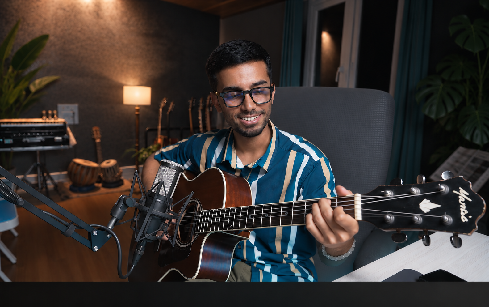 Saikat De playing guitar in his studio - Passionate Music Educator